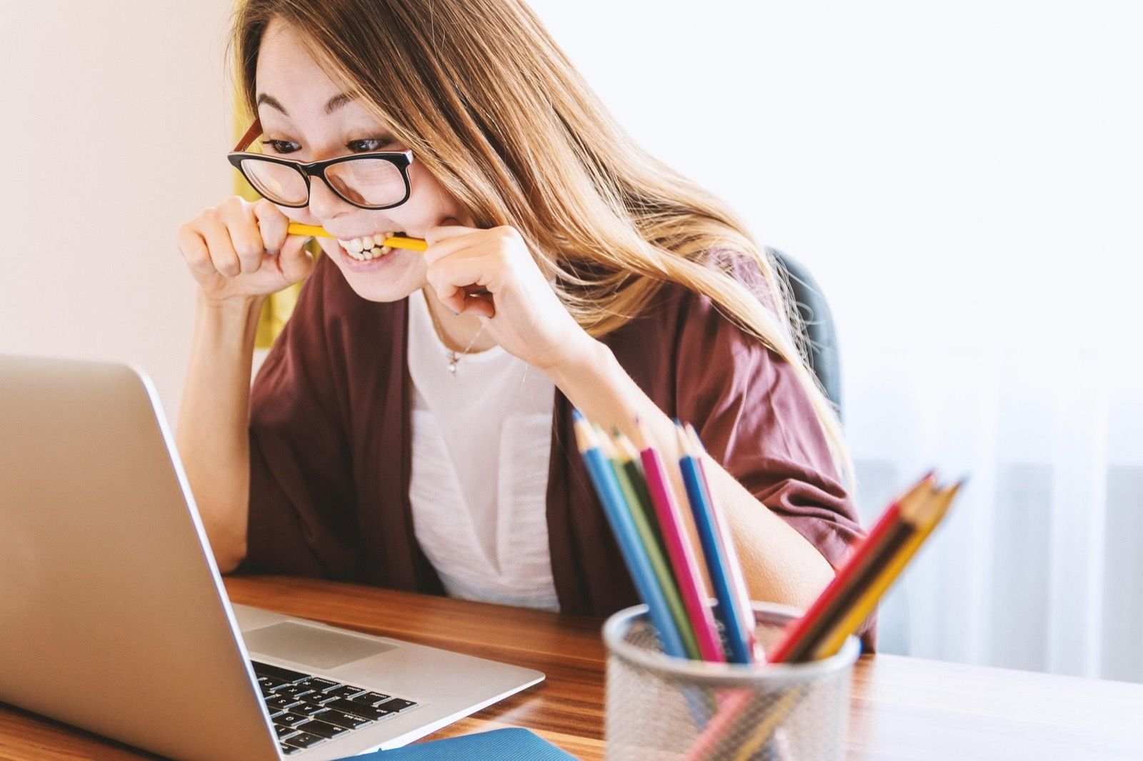 A young adult reviewing coursework with a laptop and notebook